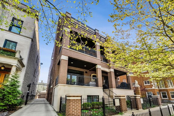 Front view of a multi-story brick building with balconies.