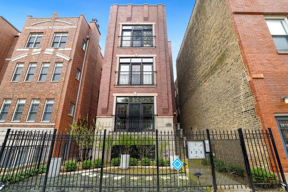 Front view of a multi-story brick building with balconies.