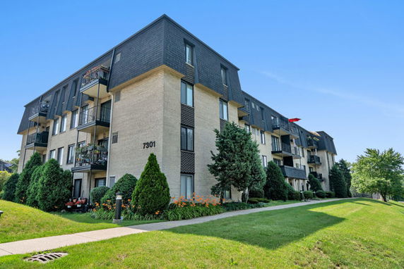 Front view of a multi-story apartment building with balconies.