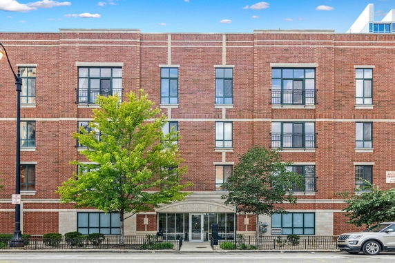 Front view of a three-story brick building with multiple windows and a central entrance.