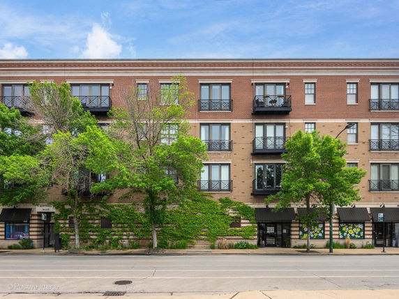 Front view of a multi-story brick building with balconies.