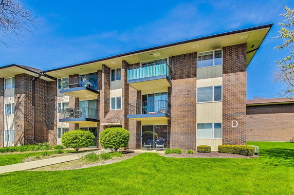 Front view of a three-story apartment building with balconies.