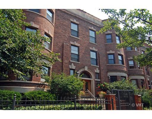 Front view of a multi-story brick building with arched entrance and symmetrical windows.