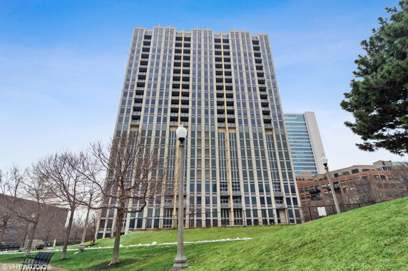 Front view of a tall residential building with multiple balconies.