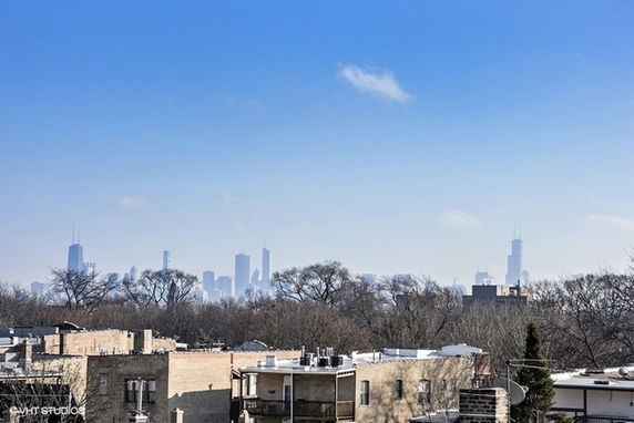 Panoramic view of city skyline and surrounding rooftops.