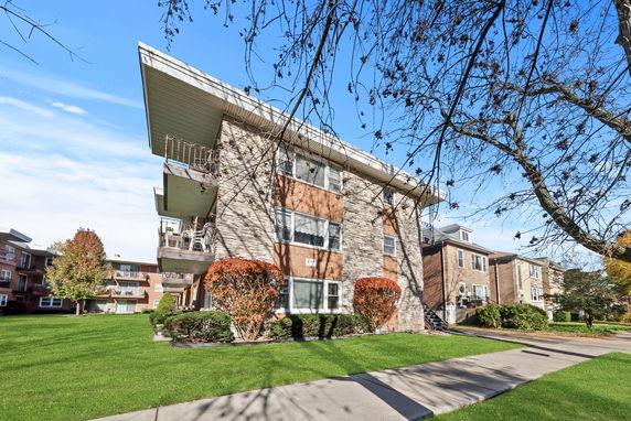Front view of a multi-story apartment building with balconies.
