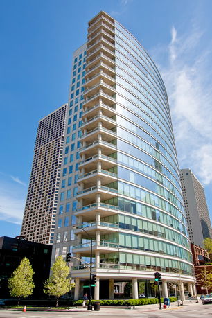Front view of a modern high-rise building with glass façade and balconies.