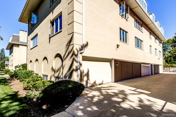 Front view of a multi-story building with multiple garages.
