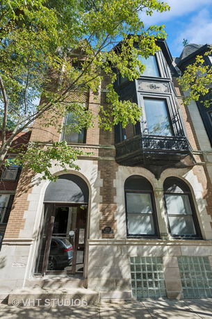 Front view of a multi-story building with arched windows and a detailed facade.