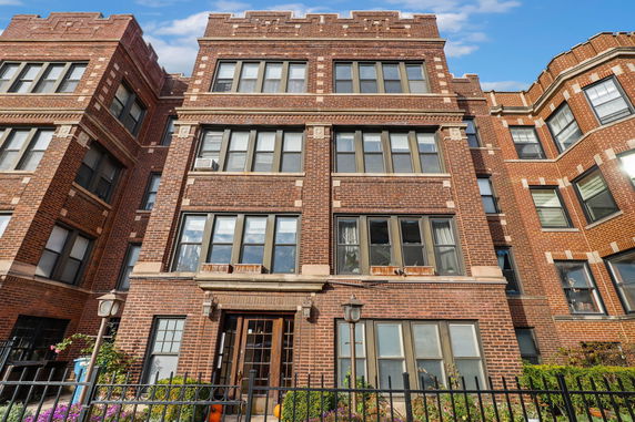 Front view of a multi-story brick building with multiple windows.
