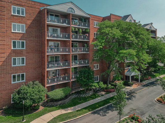 Front view of a multi-story apartment building with balconies and a brick exterior.