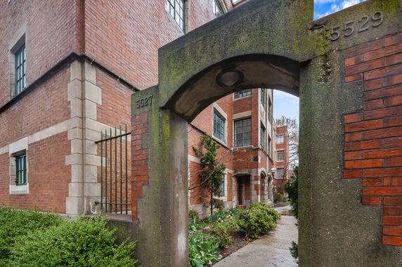 Front view of a brick residential building with archway entrance.