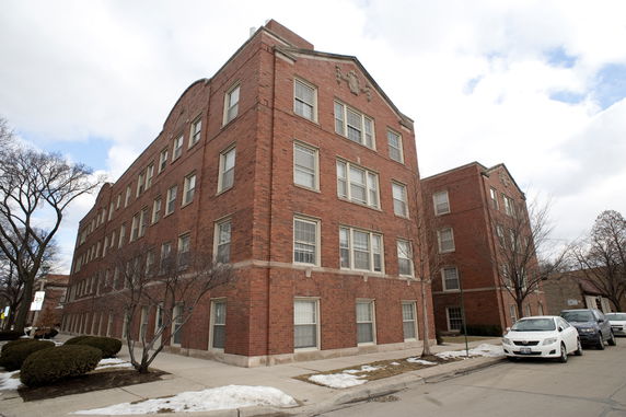 Front view of a four-story brick apartment building.