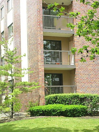 Side view of a brick apartment building with balconies.