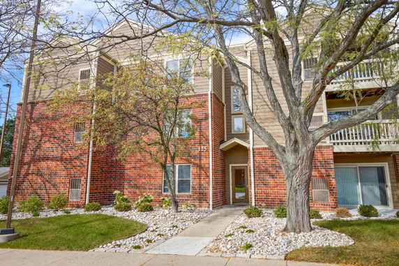 Front view of a multi-story building with brick and siding exterior.