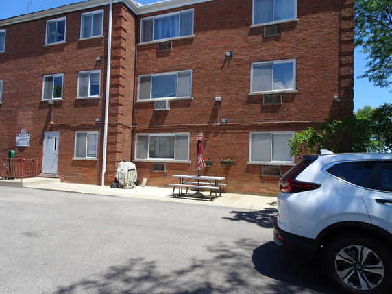 Front view of a multi-story brick building with several windows and a door.