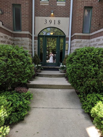 Front view of a building entrance with brick and stone facade.