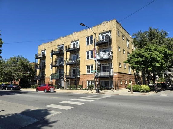 Front view of a multi-story apartment building with balconies.