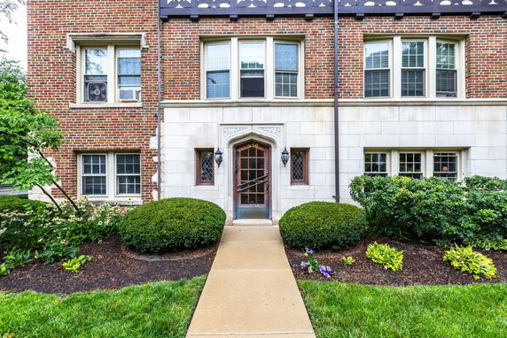 Front view of a brick building with multiple windows and a decorative entrance.