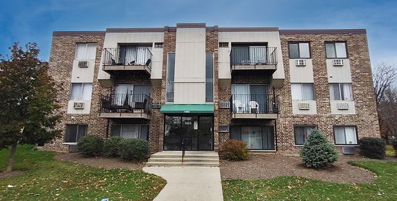 Front view of a multi-story brick building with balconies.