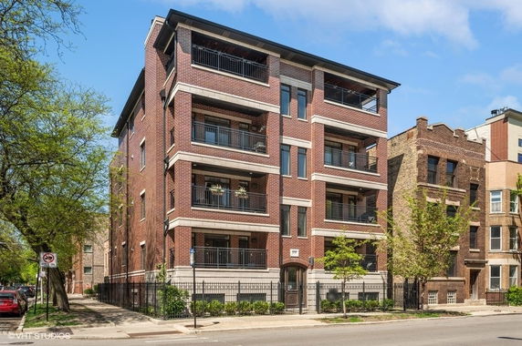 Front view of a multi-story apartment building with balconies.