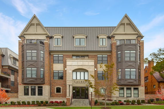 Front view of a multi-story building with balconies and a gabled roof.