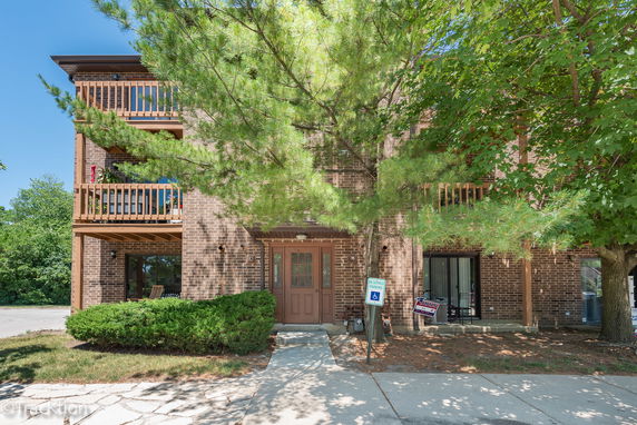Front view of a multi-story brick building with balconies.