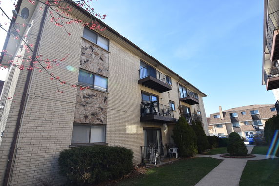 Front view of a multi-story residential building with balconies.