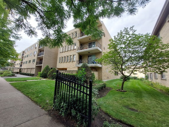 Front view of a multi-story apartment building with balconies.