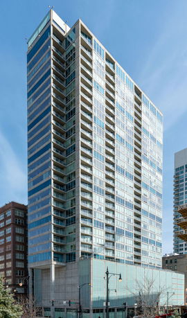 Front view of a multi-story apartment building with glass façade.