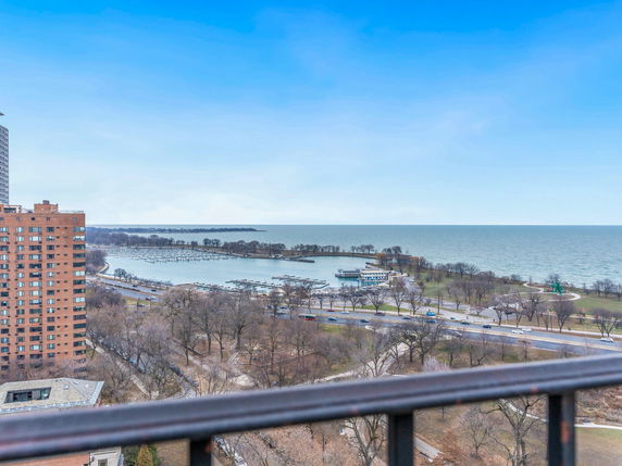 Panoramic view of a coastline with buildings, road, and body of water.