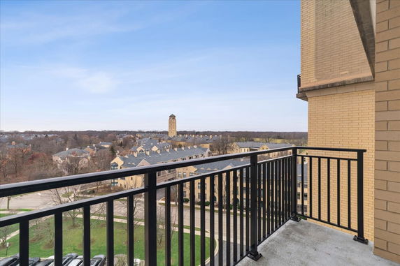 View from a balcony overlooking a residential area with a distant tower.