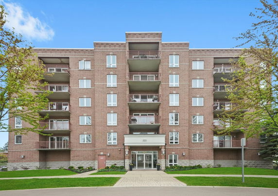 Front view of a multi-story brick building with balconies.