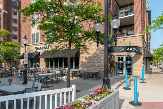 Front view of a commercial building with outdoor seating.