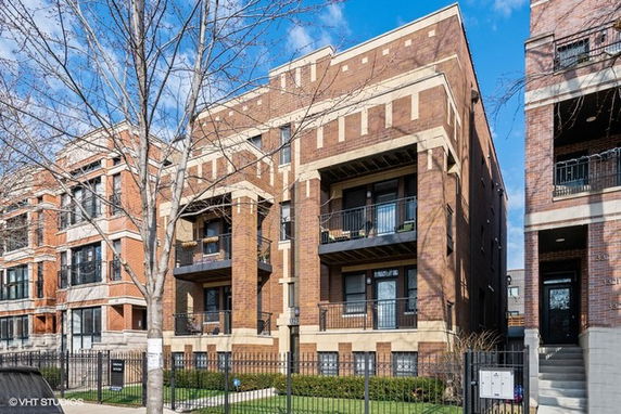 Front view of a multi-story brick building with balconies.