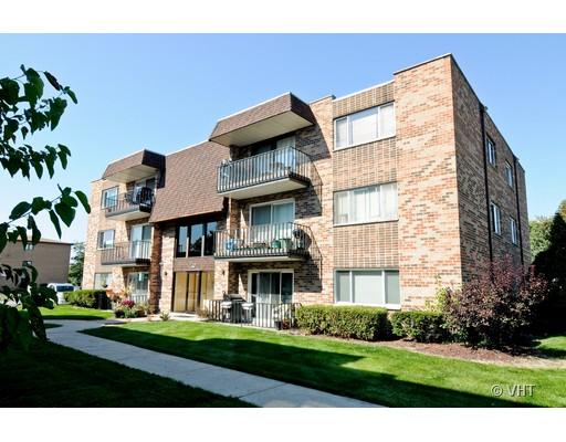 Front view of a multi-story brick apartment building with balconies.