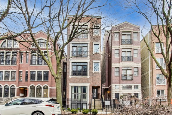 Front view of a multi-story brick apartment building with balconies.