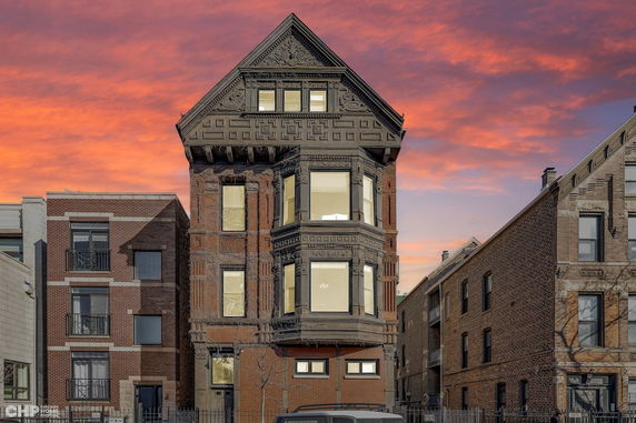 Front view of a three-story brick house with decorative architectural detailing.