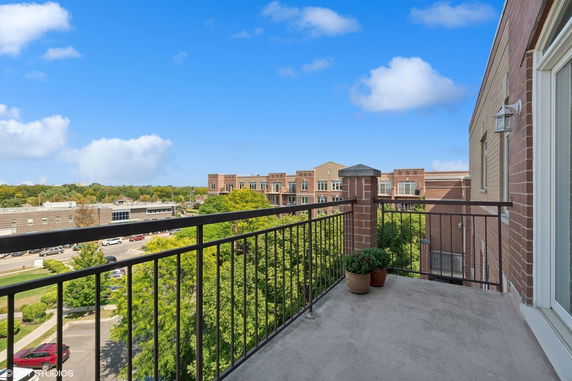 View from a balcony overlooking buildings and greenery.