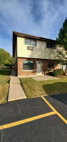 Front view of a two-story house with brick and siding exterior.
