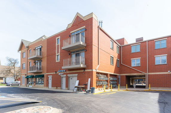 Front view of a multi-story brick building with balconies.