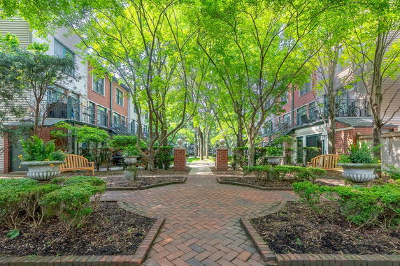Outdoor view of a residential building courtyard with trees and benches.