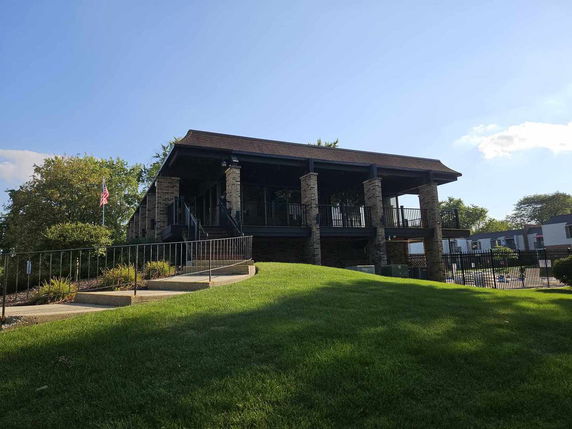 Front view of a two-story building with brick columns and a sloped roof.