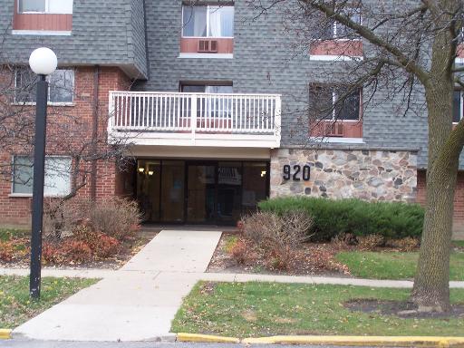 Front view of a multi-story residential building with a stone and brick facade.