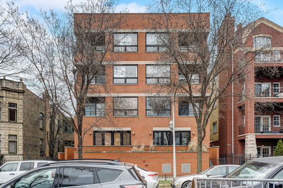 Front view of a four-story brick apartment building.