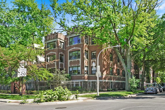 Front view of a brick apartment building with multiple floors.