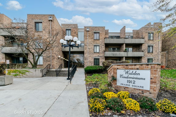 Front view of a multi-story condominium building with a brick facade and balconies.