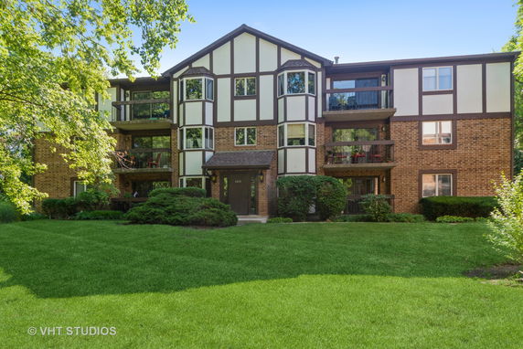Front view of a three-story residential building with brick and panel siding.