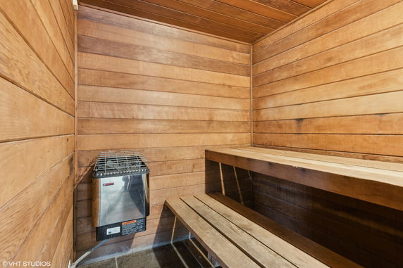 Interior view of a wooden sauna room with a bench and heater.