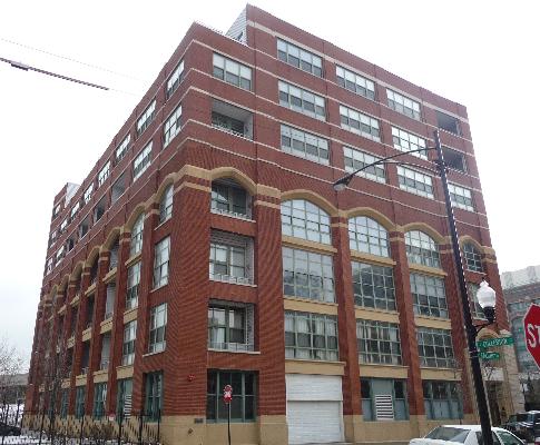 Front view of a multi-story brick building with large windows.